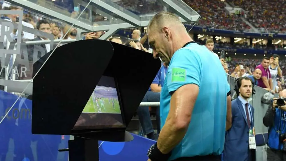 football referee checking a foul on VAR