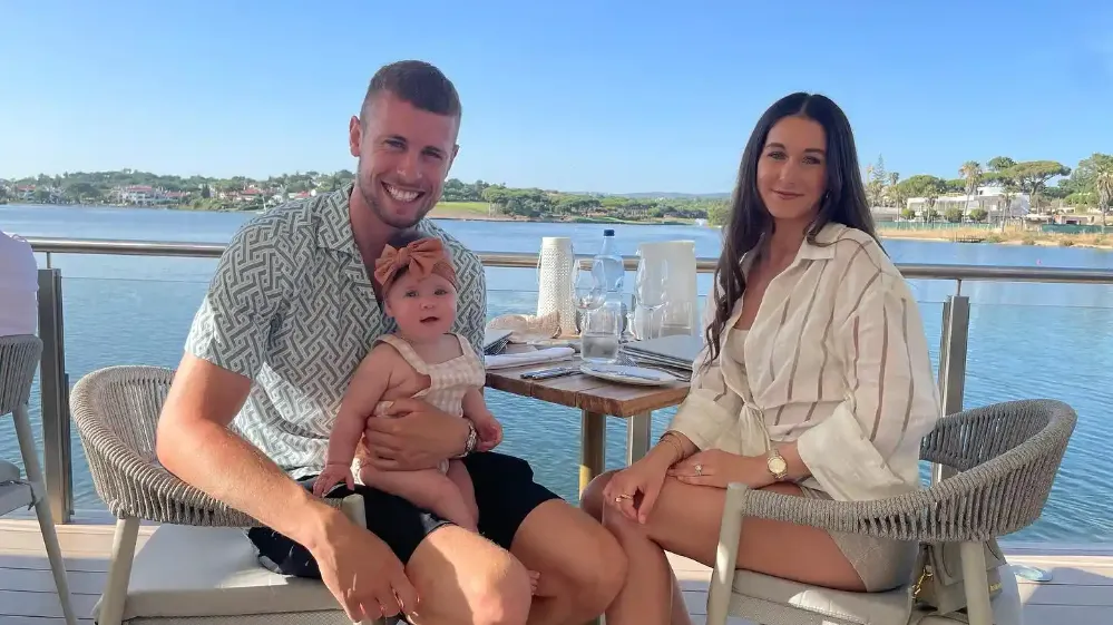 adam webster and melissa webster and their child having a lunch at a lake