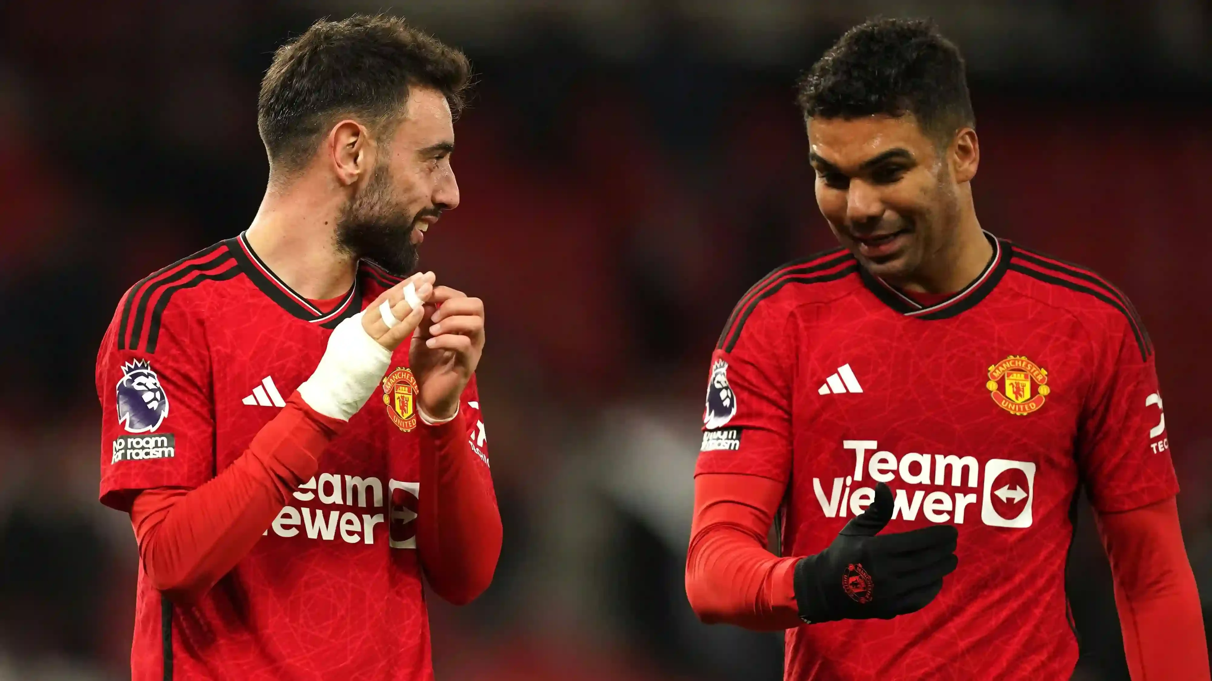 Bruno Fernandes and Casemiro share a moment of discussion on the pitch during a Manchester United match.