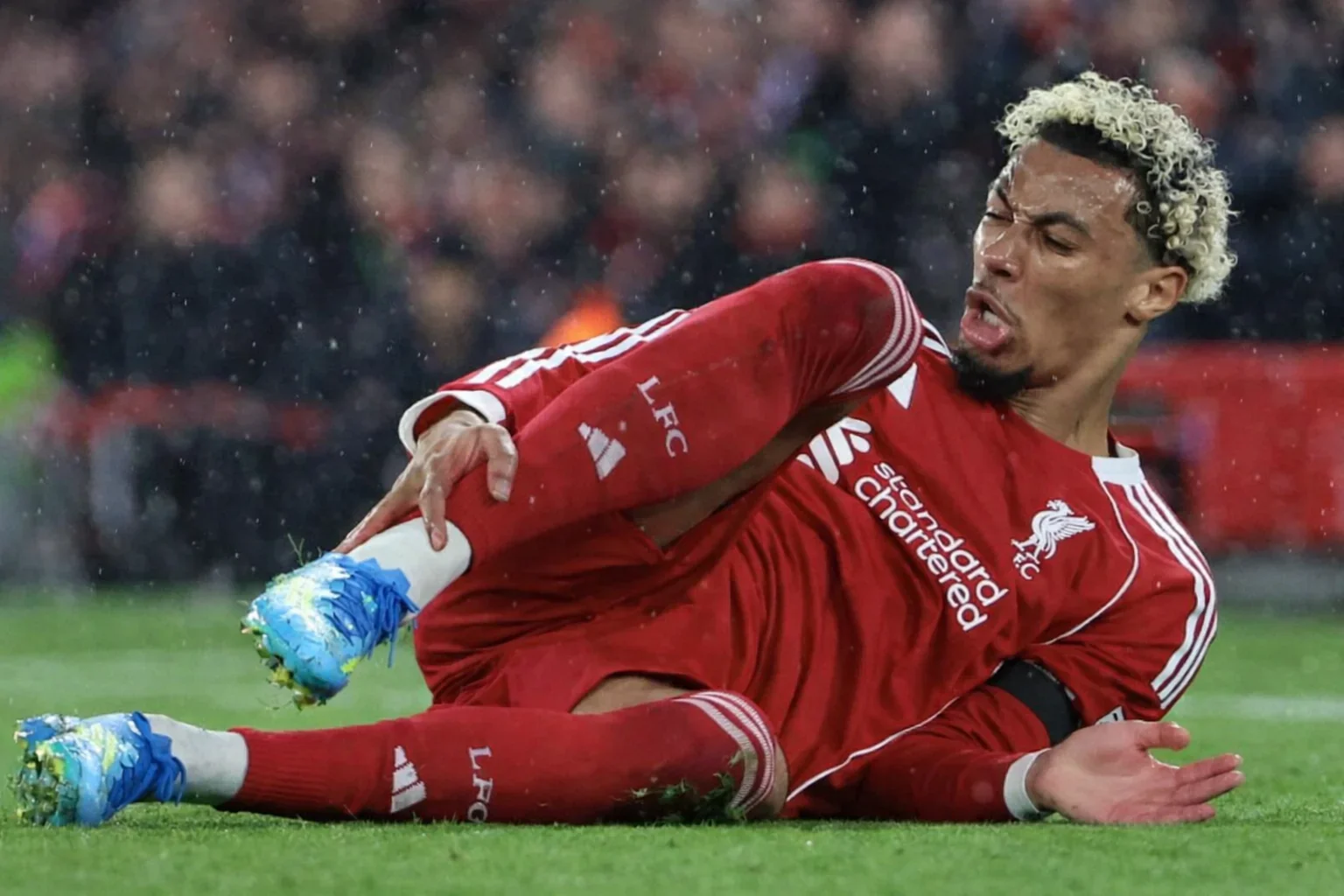 Hugo Ekitike in red Liverpool kit lying on the pitch during a match after an injury