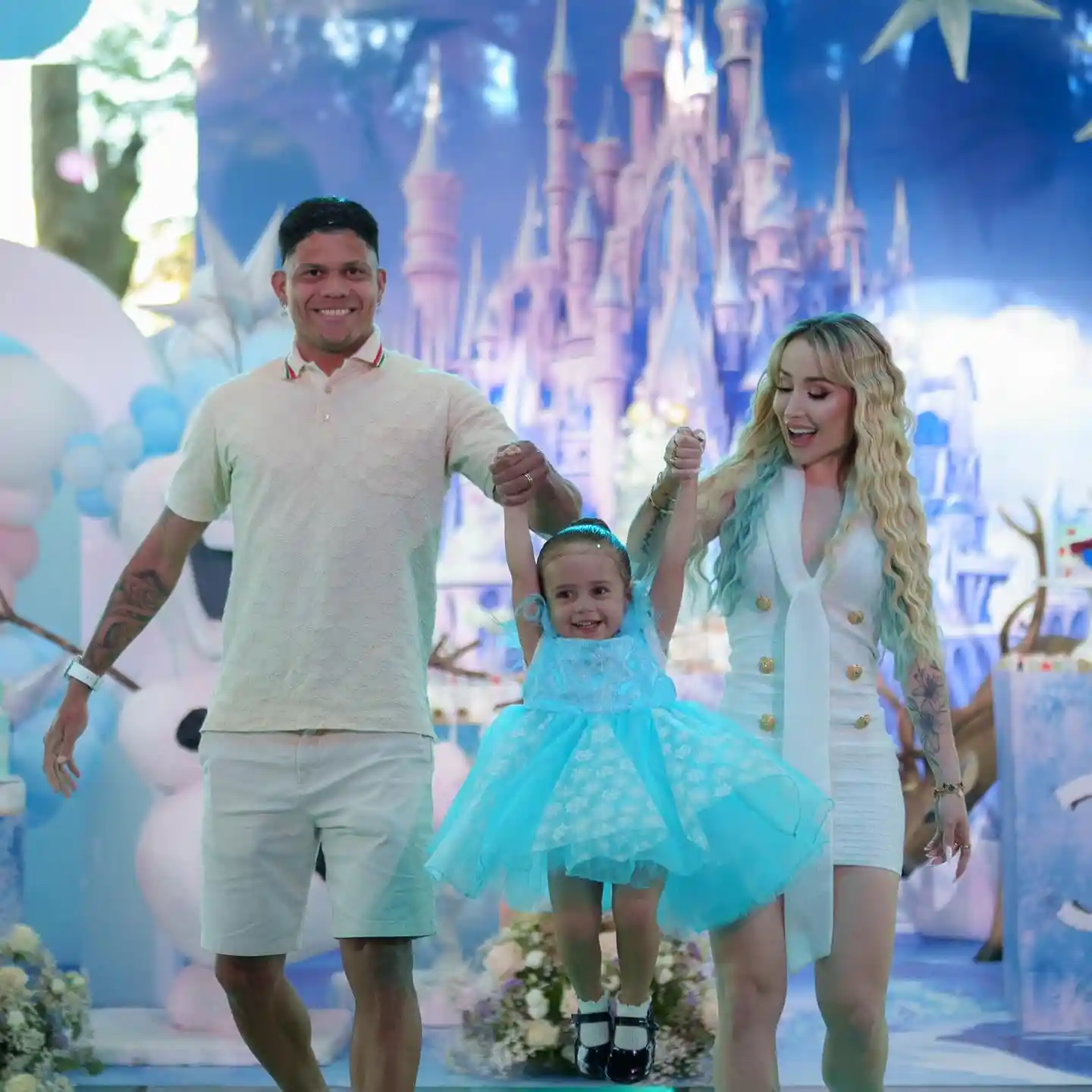 evanilson and mariana abreu lifting their daughter in the air at her birthday