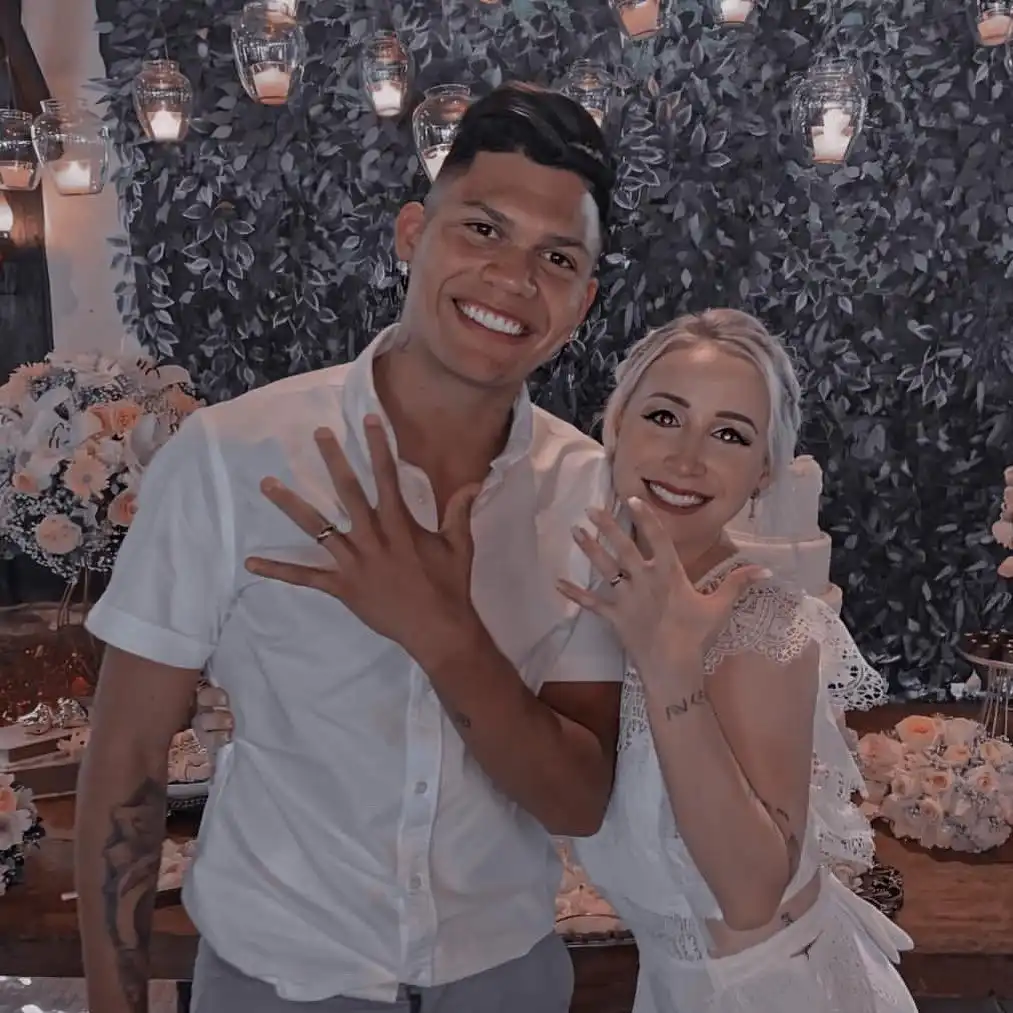 evanilson and his wife mariana abreu posing with their wedding rings