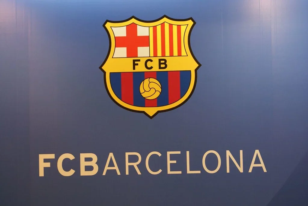 FC Barcelona club crest on a blue background with ‘FCBARCELONA’ text below.