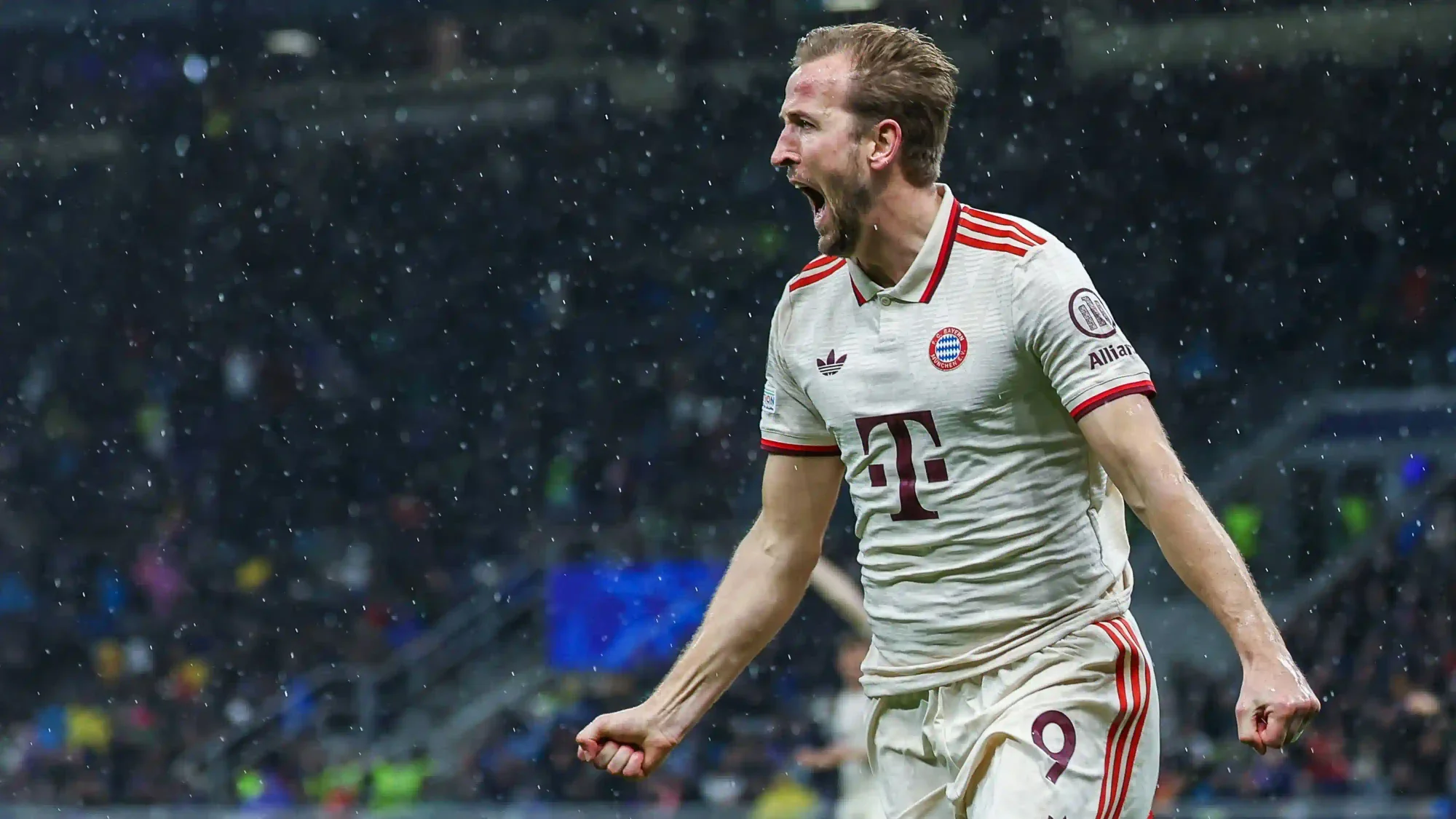 Harry Kane celebrates a goal for Bayern Munich in a white kit during a match