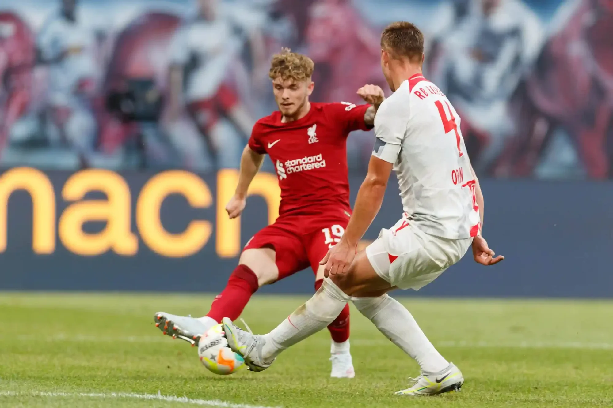 Harvey Elliott in a Liverpool kit challenges for the ball during a match.
