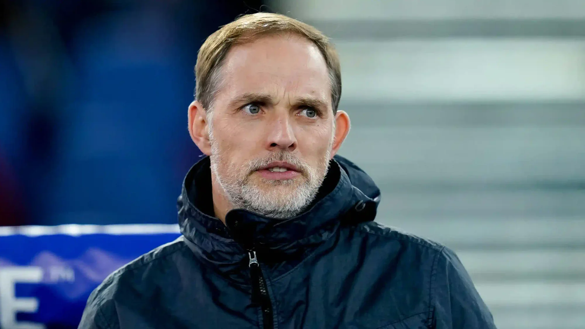 Thomas Tuchel during a match, standing on the sideline in a winter coat.