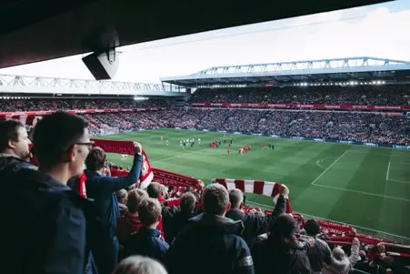 liverpool supporters at anfield holding liverpool scarfs