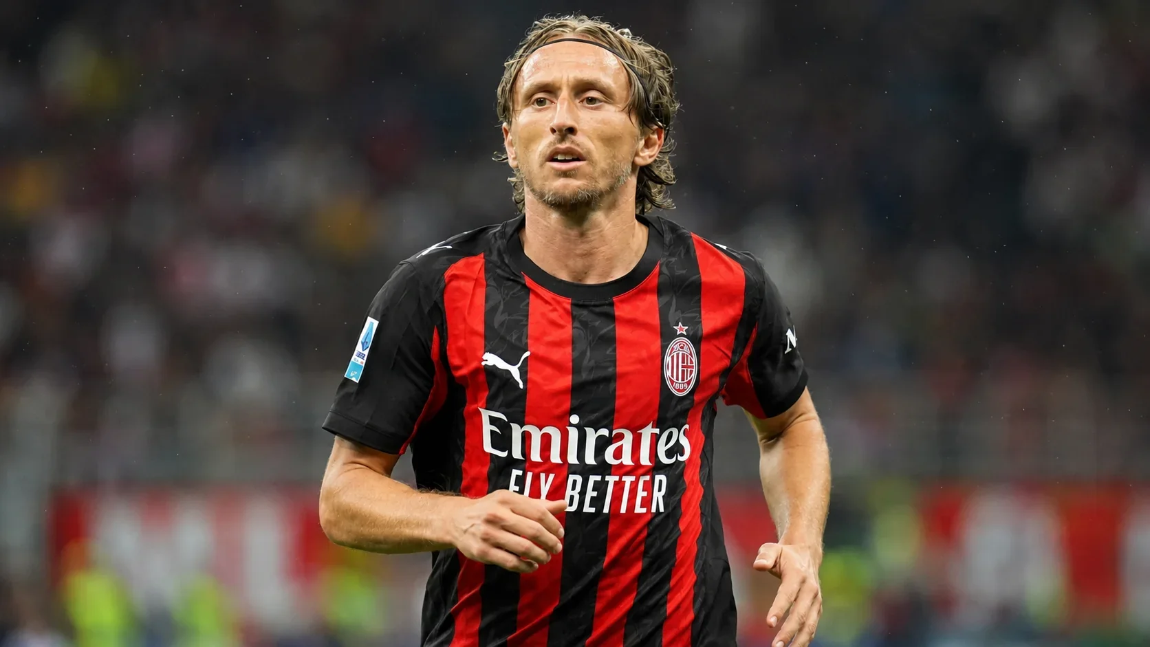 Luka Modrić running in an AC Milan shirt during a match