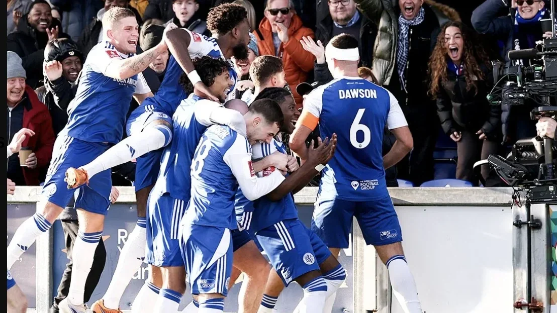 Macclesfield celebrate with the crowd after winning an important match.