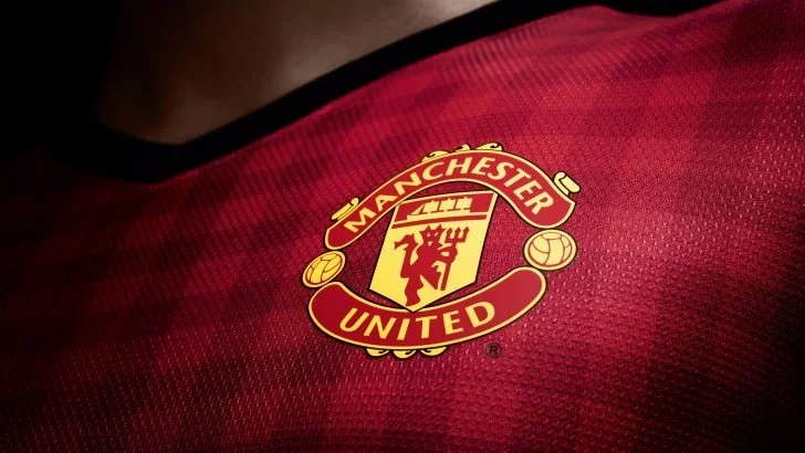 Close-up of the Manchester United club crest on a red jersey.