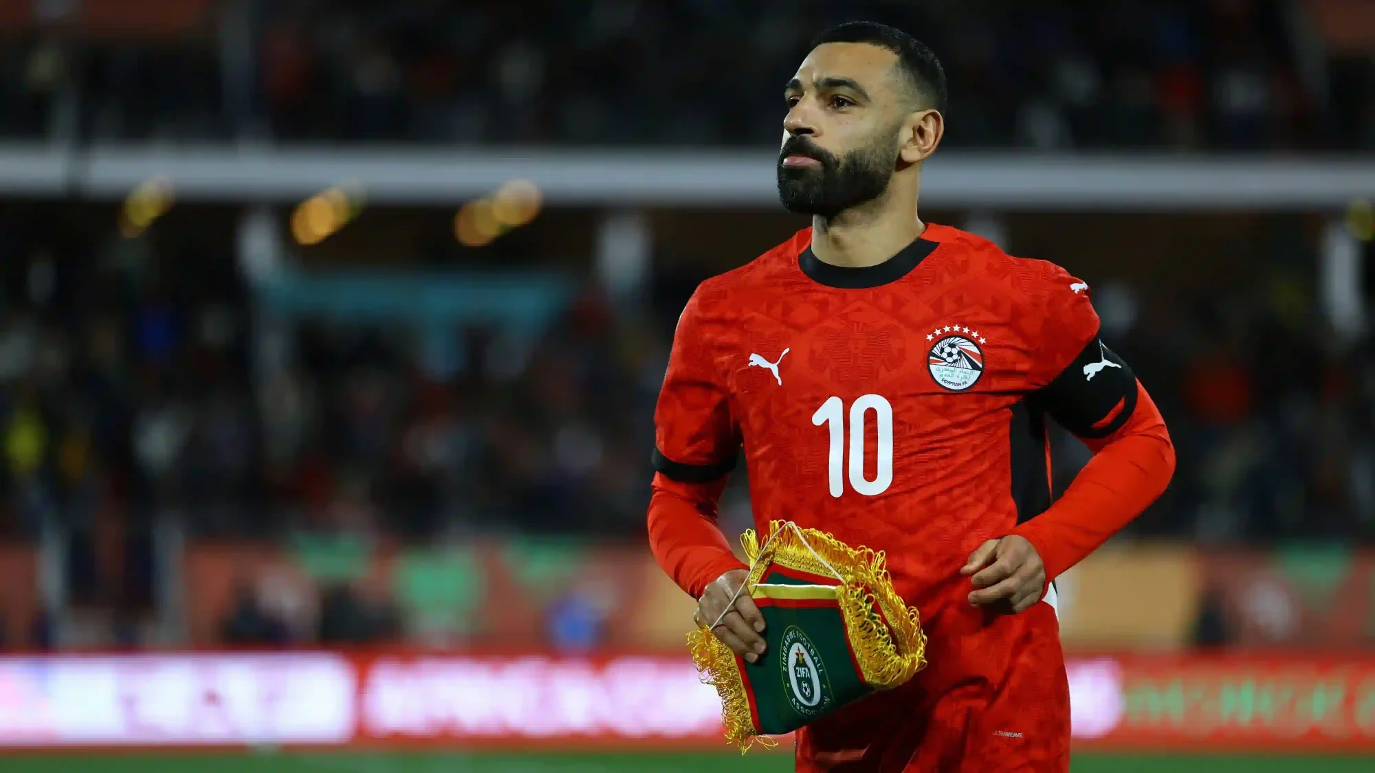 Mohamed Salah in Egypt’s number 10 shirt holds a pennant before a match.