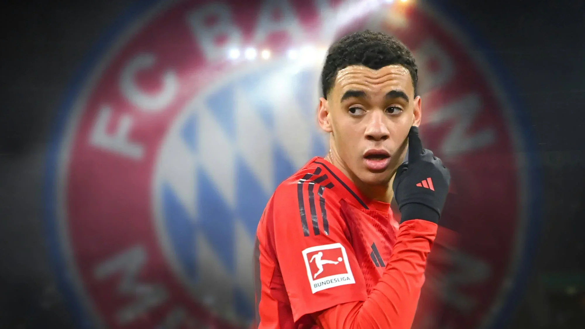 Jamal Musiala in action for Bayern Munich with club crest visible in the background