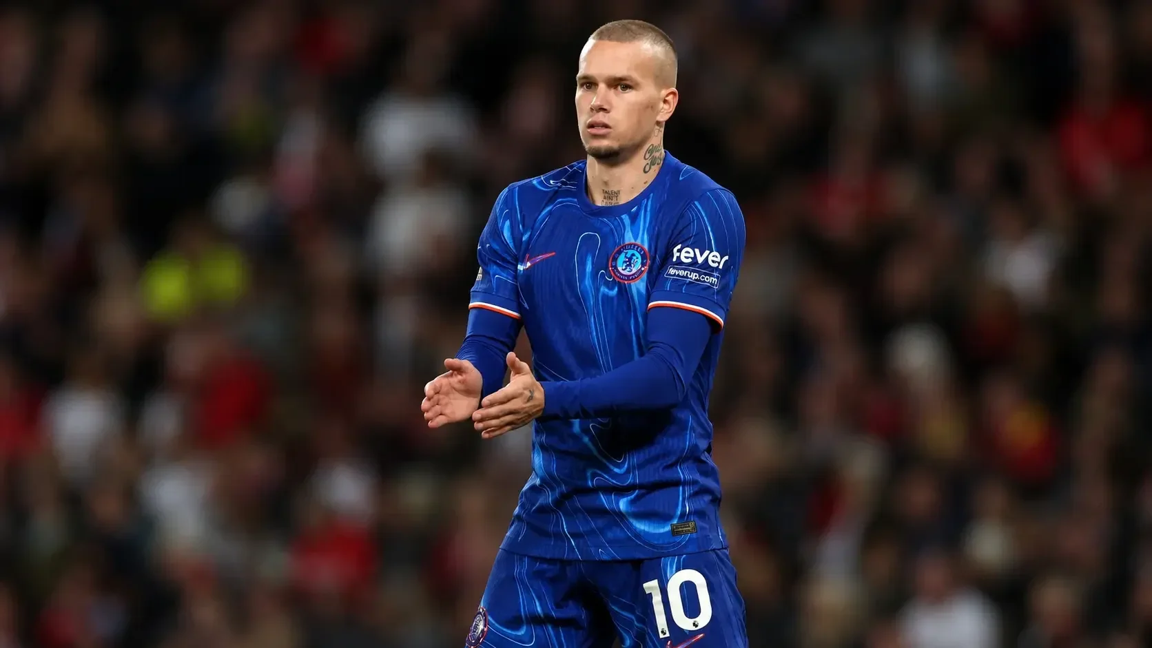 Mykhailo Mudryk applauding in a Chelsea shirt during a match