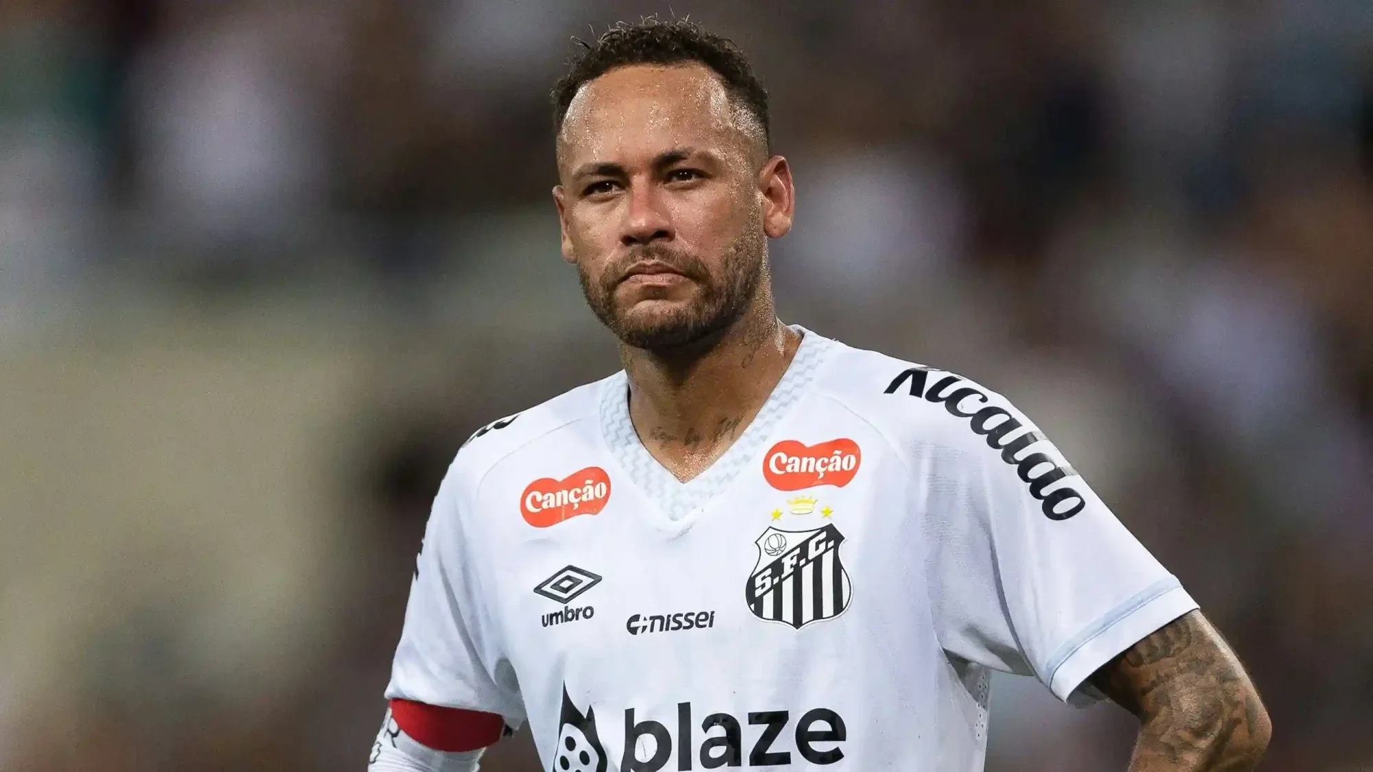 Neymar stands on the pitch wearing Santos’ white kit with a captain’s armband.