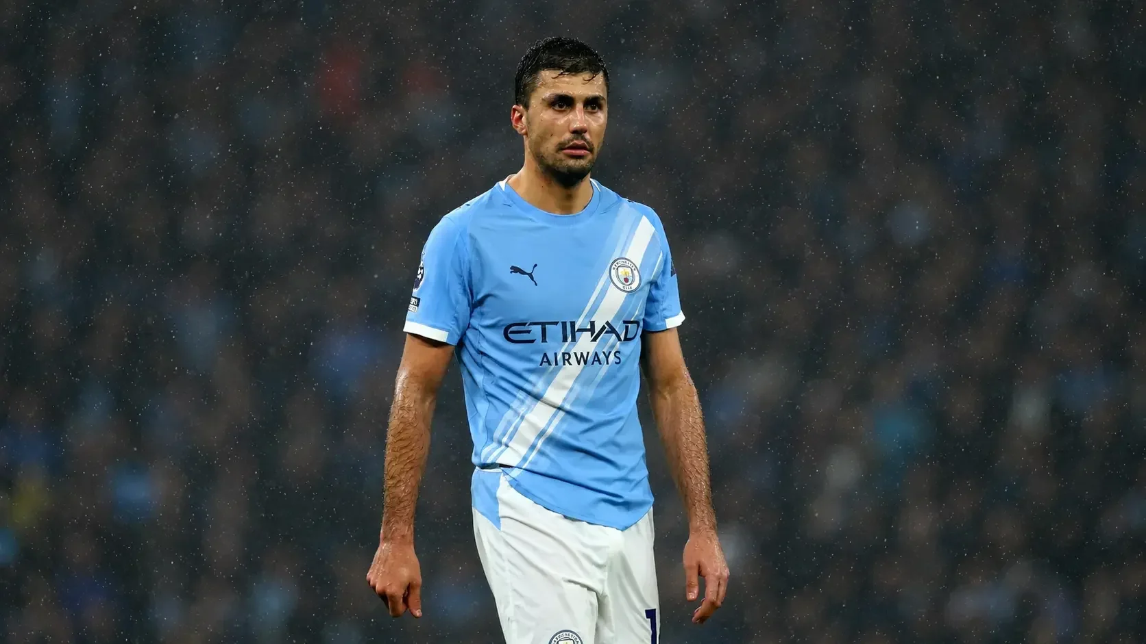Rodri standing in Manchester City’s kit during a rainy match