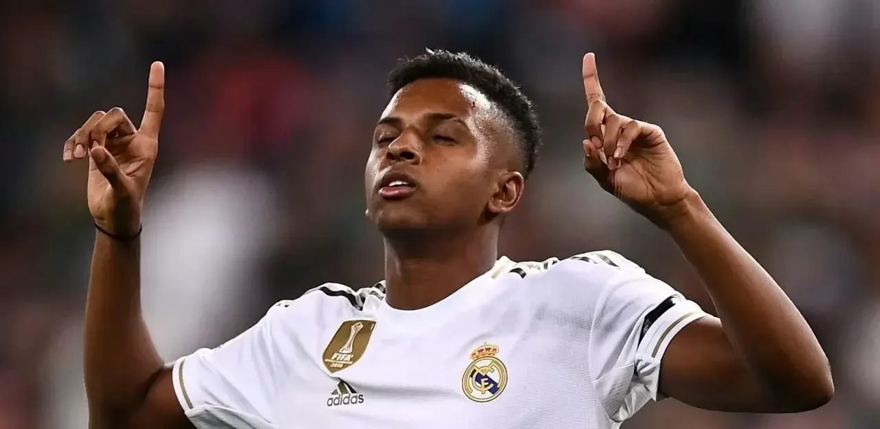 Rodrygo celebrates for Real Madrid with both index fingers raised during a match.