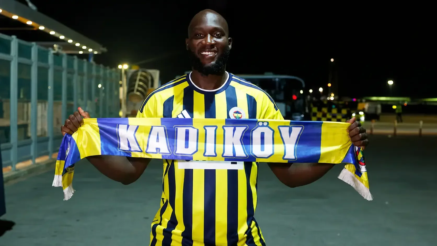 Romelu Lukaku holding a Kadıköy scarf while wearing a Fenerbahçe shirt