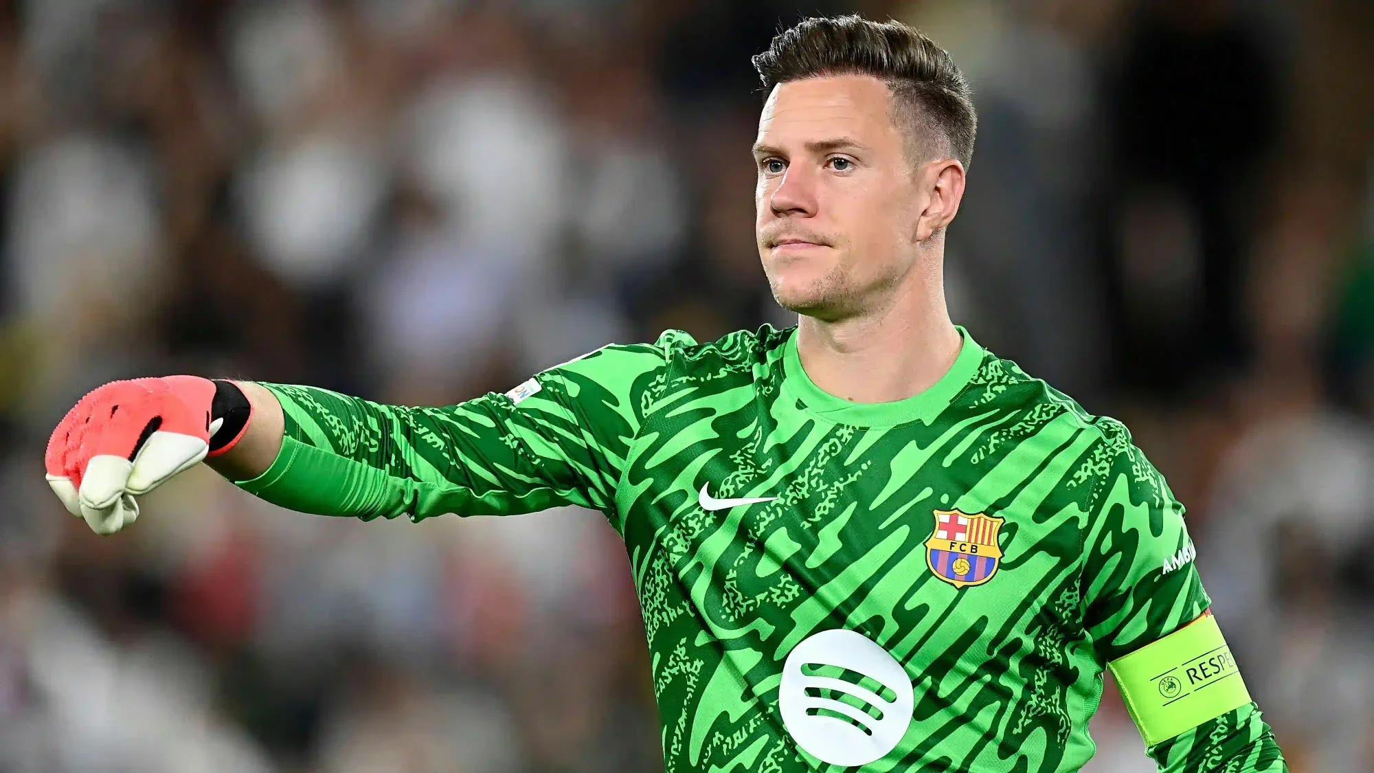 marc-andré ter stegen points during a match while wearing barcelona’s green goalkeeper kit